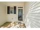 Covered front porch with storm door and adjacent window with black shutters at 8253 Martello Ln, Raleigh, NC 27613