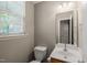 Half bath featuring a single sink vanity and window with blinds for privacy at 8253 Martello Ln, Raleigh, NC 27613