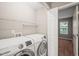 A convenient laundry room with modern washer and dryer units, plus built in shelving for storage at 8253 Martello Ln, Raleigh, NC 27613