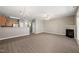 Open-concept living room with hardwood floors, fireplace, chandelier, and access to the kitchen and front entry at 8253 Martello Ln, Raleigh, NC 27613