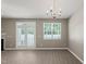 Bright living room featuring hardwood floors, a chandelier, and sliding glass doors for ample natural light at 8253 Martello Ln, Raleigh, NC 27613