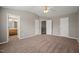 Spacious main bedroom featuring plush carpet, a ceiling fan, and doors leading to the closet and main bathroom at 8253 Martello Ln, Raleigh, NC 27613