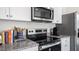 Modern kitchen featuring stainless steel appliances and granite countertops with stylish fixtures at 8544 Beckett Chase Way, Raleigh, NC 27616