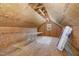 A unfinished attic space with plywood walls and ceiling, table and insulation at 91 Carsons Creek Trl, Wendell, NC 27591