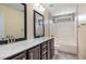 Bathroom featuring double sinks, dark wood cabinets and a shower-tub combo with tiled walls at 91 Carsons Creek Trl, Wendell, NC 27591