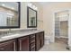 The bathroom has double sinks, granite countertop, dark wood cabinets, and a walk-in shower at 91 Carsons Creek Trl, Wendell, NC 27591