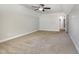 A carpeted bedroom with neutral walls, a ceiling fan, and an entry to another room at 91 Carsons Creek Trl, Wendell, NC 27591