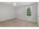 This bedroom features neutral walls and carpet, plus a ceiling fan and a window at 91 Carsons Creek Trl, Wendell, NC 27591