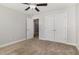 A carpeted bedroom with neutral walls, a ceiling fan, and double door closet at 91 Carsons Creek Trl, Wendell, NC 27591