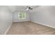 A carpeted bedroom with neutral walls, a ceiling fan, and a large window at 91 Carsons Creek Trl, Wendell, NC 27591