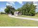 Wide shot of a home with a long driveway and detached garage surrounded by lush greenery at 91 Carsons Creek Trl, Wendell, NC 27591