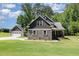 Beautiful stone and shingle two-story home with a lush green lawn and a detached garage at 91 Carsons Creek Trl, Wendell, NC 27591