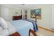 Bright bedroom featuring a dresser, artwork, and a comfortable bed with a blue blanket at 945 St Marys St, Raleigh, NC 27605