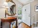 Elegant foyer featuring hardwood floors, staircase, decorative mirror and front door at 945 St Marys St, Raleigh, NC 27605