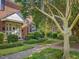 Charming brick townhouse featuring mature trees, walkway and well-maintained landscaping at 945 St Marys St, Raleigh, NC 27605