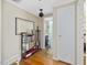 Hallway with hardwood floors and a decorative bookshelf and view into a bathroom at 945 St Marys St, Raleigh, NC 27605