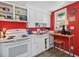 Compact kitchen with white cabinets, open shelving, and a bright red accent wall at 945 St Marys St, Raleigh, NC 27605