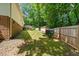 Spacious backyard with lush greenery, deck, storage sheds and privacy fence at 1004 Candlewood Cir, Siler City, NC 27344