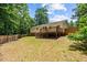 Spacious backyard featuring a wooden deck and fenced perimeter, perfect for outdoor activities at 1004 Candlewood Cir, Siler City, NC 27344