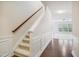 Bright hallway featuring hardwood floors, carpeted stairs and decorative wainscoting at 1009 Magnolia Leaf Ct, Apex, NC 27502