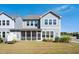 Exterior view of the home's backyard with a well-maintained lawn and a screened in porch at 101 Rostova Way, Holly Springs, NC 27540