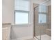 Bright bathroom featuring a glass-enclosed shower, granite countertops, and a window at 101 Rostova Way, Holly Springs, NC 27540