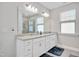 Bathroom featuring double vanity, large mirror, and a tiled glass-enclosed shower at 101 Rostova Way, Holly Springs, NC 27540