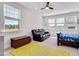 Bright bedroom with multiple windows, ceiling fan, couch, a toddler bed and chest at 101 Rostova Way, Holly Springs, NC 27540