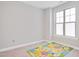Neutral bedroom with a large window with carpeted floor and colorful playmat at 101 Rostova Way, Holly Springs, NC 27540
