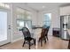 Well-lit dining room featuring a table with six chairs, windows, and a refrigerator in the background at 101 Rostova Way, Holly Springs, NC 27540