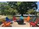 Outdoor fire pit surrounded by colorful Adirondack chairs provides a relaxing space for gathering with friends at 101 Rostova Way, Holly Springs, NC 27540