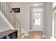 Light-filled foyer with hardwood floors and a staircase leads to the upper level at 101 Rostova Way, Holly Springs, NC 27540