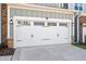 The two car garage door is white and sports black iron hardware at 101 Rostova Way, Holly Springs, NC 27540