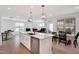 Bright kitchen features a center island with a sink, stainless steel appliances, and an open floor plan at 101 Rostova Way, Holly Springs, NC 27540