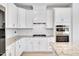 Modern kitchen featuring white cabinets, granite countertops, stainless steel appliances, and a center island at 101 Rostova Way, Holly Springs, NC 27540