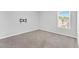 A well-lit bedroom with neutral walls, plush carpeting, and a window for natural light at 103 Norris Creek Dr, Clayton, NC 27527