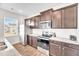 Stylish kitchen with stainless-steel appliances, granite countertops, and dark wood cabinetry at 103 Norris Creek Dr, Clayton, NC 27527