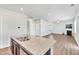 Open kitchen featuring granite countertops and stainless steel appliances flowing into the spacious living area at 103 Norris Creek Dr, Clayton, NC 27527