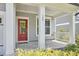 Welcoming front porch with a vibrant red door, classic white columns, and well-maintained landscaping at 120 Chapel Run Way, Chapel Hill, NC 27517