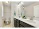 Bright bathroom featuring double sinks, a large mirror, and a separate toilet area at 121 Martingale Dr, Holly Springs, NC 27540