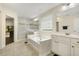 Bright primary bath featuring double vanities, soaking tub, and glass enclosed shower with bench at 121 Martingale Dr, Holly Springs, NC 27540