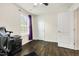 Well lit bedroom featuring a ceiling fan and dark wood laminate flooring at 121 Martingale Dr, Holly Springs, NC 27540