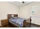 Cozy bedroom with a wooden bed frame, blue patterned bedding, a nightstand, and a bright window at 121 Martingale Dr, Holly Springs, NC 27540