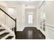 Bright foyer featuring hardwood floors, wainscoting, and access to upper level at 121 Martingale Dr, Holly Springs, NC 27540