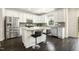 Modern kitchen with stainless steel appliances, gray backsplash, white cabinets, island with seating, and dark hardwood floors at 121 Martingale Dr, Holly Springs, NC 27540