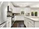 Bright kitchen featuring stainless steel appliances, white cabinets, and dark wood floors at 121 Martingale Dr, Holly Springs, NC 27540