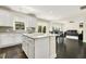 Open-concept kitchen with island, white cabinetry and appliances with a view to a dining and living room at 121 Martingale Dr, Holly Springs, NC 27540