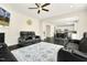 Open concept living room with black leather reclining seating, fireplace, and a view into the kitchen at 121 Martingale Dr, Holly Springs, NC 27540