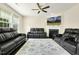 Spacious living room features plush leather sofas, a fireplace, and plenty of natural light at 121 Martingale Dr, Holly Springs, NC 27540