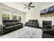 Spacious living room with black leather seating, fireplace, and plenty of natural light from large windows at 121 Martingale Dr, Holly Springs, NC 27540